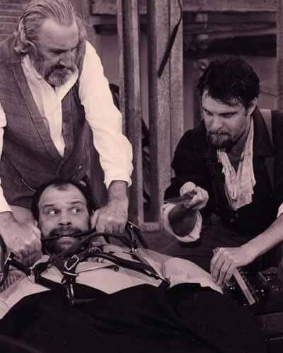 Coriolanus — Gideon Heath (credited as Bill Baker) awaits an arm amputation performed by Randy Pryce while Sam Mackey looks on, Summer 1997